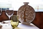 vaso porta fiori di ceramica decorato a mano sul tavolo del ristorante con bicchieri della collezione terzo cielo ceramica di Castelli De Fabritiis Teramo Abruzzo