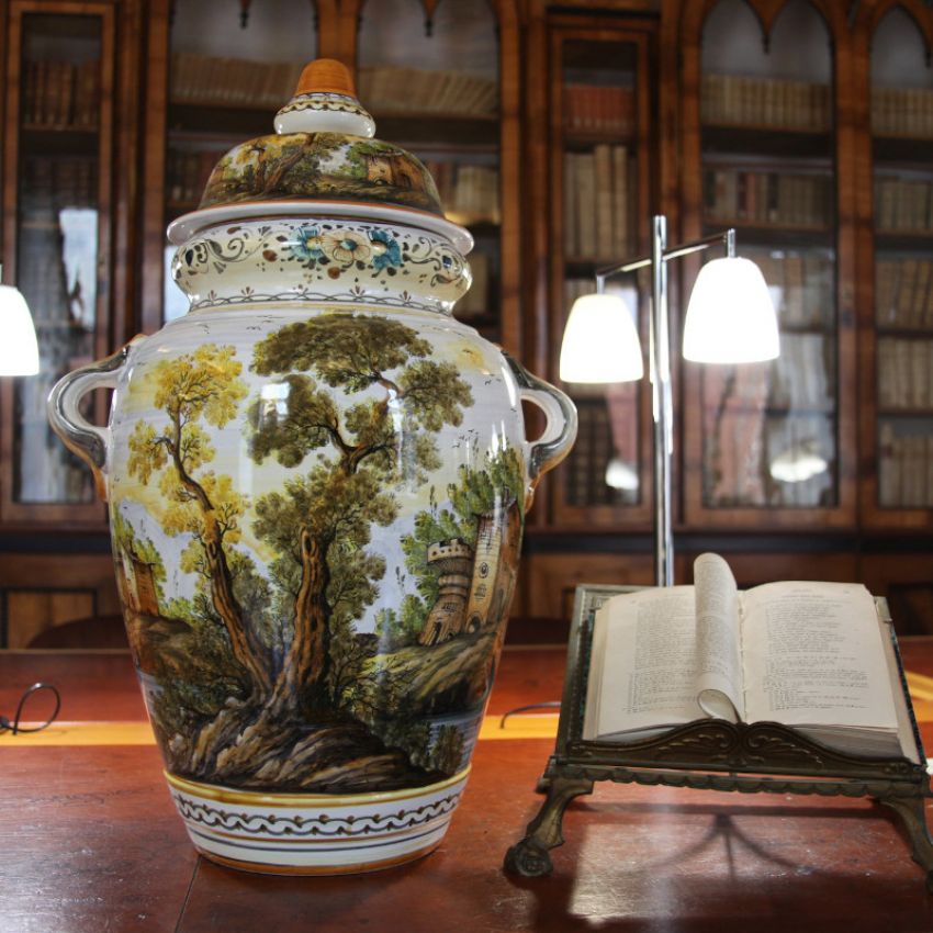 Collezione Paesaggi su vaso di ceramica di Castelli posizionata sul tavolo della biblioteca