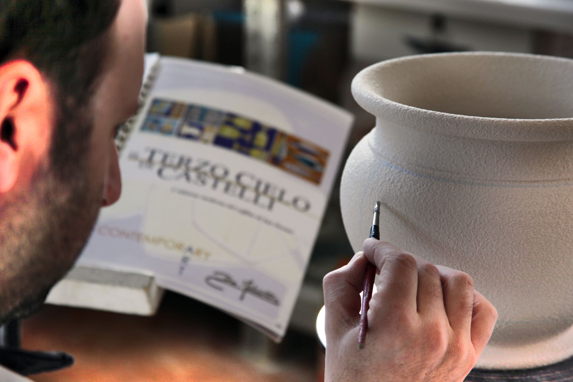 pittore che dipinge un vaso della collezione Terzo Cielo maiolica ceramica di De Fabritiis a Castelli di Teramo in Abruzzo