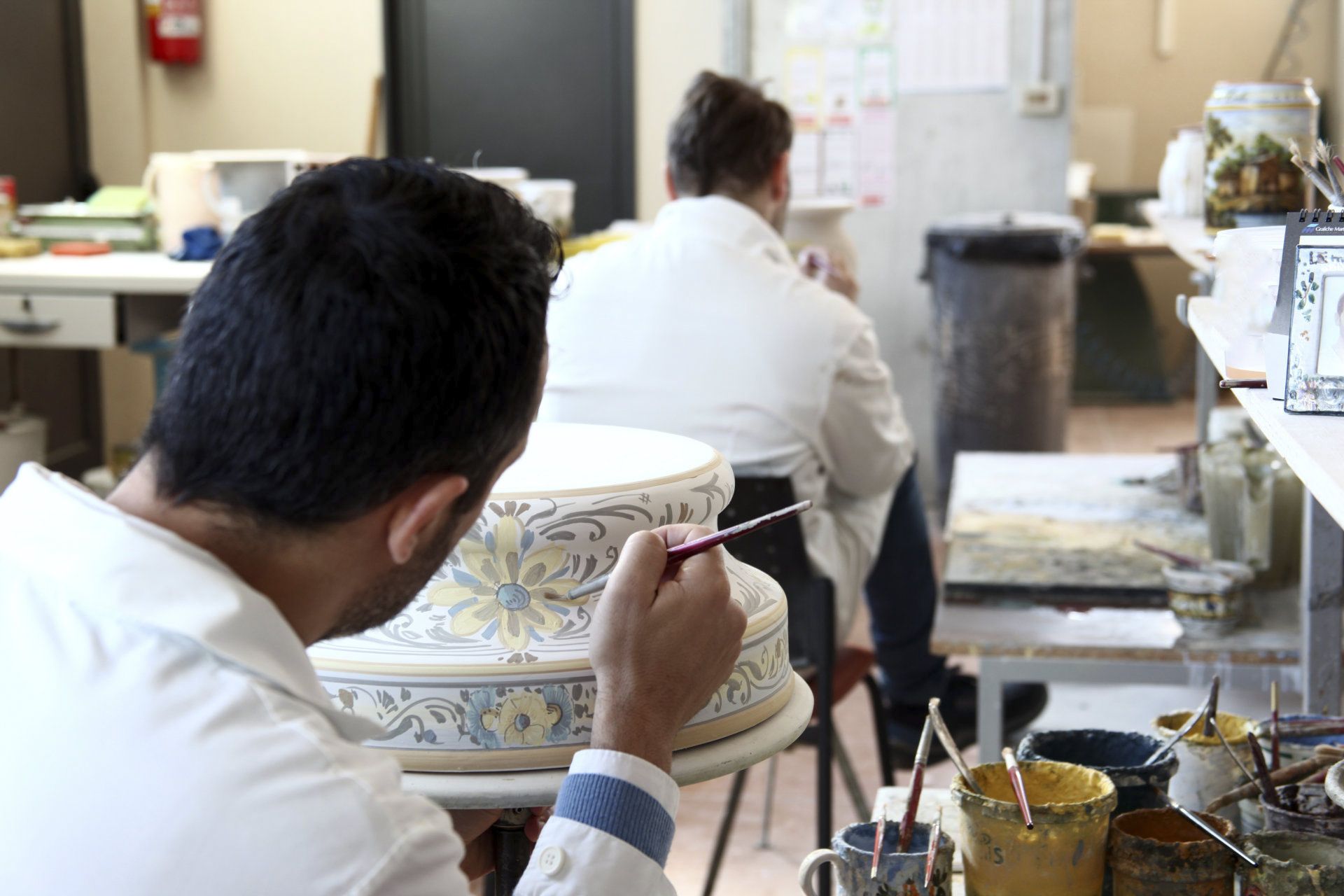 laboratorio artigianale  con pittori che dipingono le maioliche di argille a Castelli in Abruzzo De Fabritiis