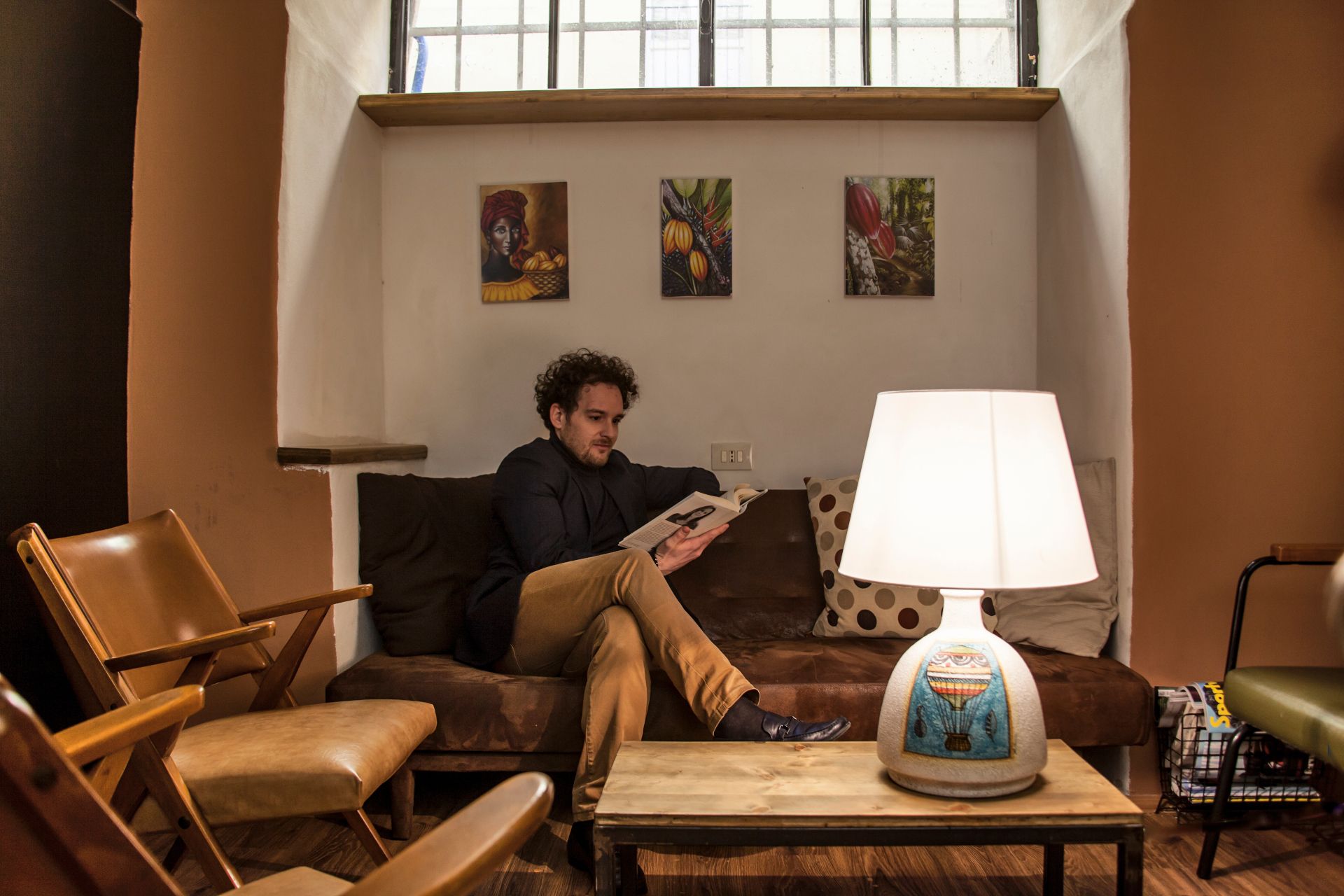 ragazzo sul divano legge un libro con lampada della collezione terzo cielo maiolica ceramica di Castelli di Teramo in Abruzzo